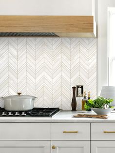 a stove top oven sitting next to a white kitchen counter topped with pots and pans