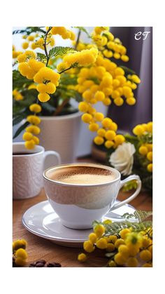 a cup of coffee sitting on top of a saucer next to some yellow flowers