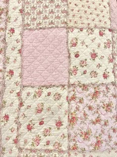 a pink and white quilt with flowers on it