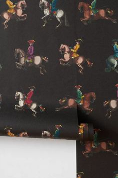 a wallpaper with horses and jockeys on black background is featured in this image