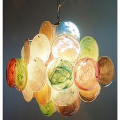 a chandelier that has many different colored glass bowls hanging from it's ceiling