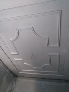 the ceiling is painted white and has an ornate design on it's sidewall