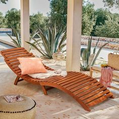 a wooden chaise lounge chair sitting on top of a patio