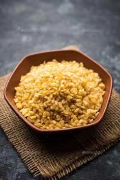 yellow rice in a brown bowl on a cloth - stock photo - images and photos