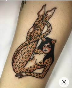 a woman with a leopard print on her leg is holding onto a cheetah