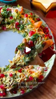 a plate with a christmas wreath made out of vegetables and other food items on it