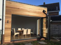 an outdoor dining area with wooden walls and sliding glass doors that open up to the backyard