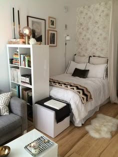 a small bedroom with a bed, couch and bookcase in the middle of it