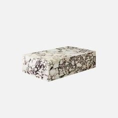 a white and black marble box sitting on top of a table