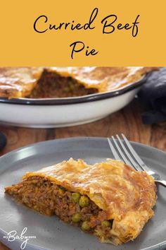 a piece of beef pie on a plate with a fork in front of the pie