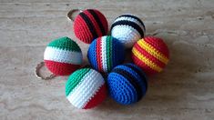 several crocheted balls are arranged in a circle on a table with a keychain