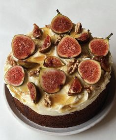 a cake topped with figs and nuts on top of a white plate