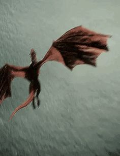 a red dragon flying through the air with its wings spread out and it's eyes open