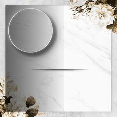 a white marble background with flowers and a round mirror