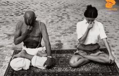 two people sitting on top of a rug next to each other