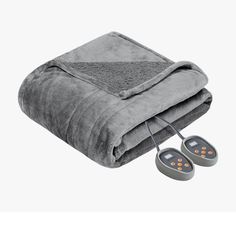 the heated blanket and two earbuds are laying next to each other