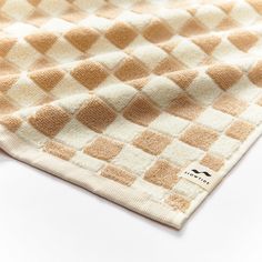 a white and brown checkered towel laying on top of a table