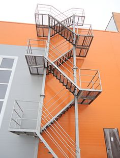 an orange building with metal railings and fire escape stairs