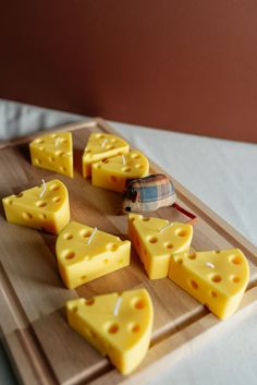 several slices of cheese are arranged on a cutting board