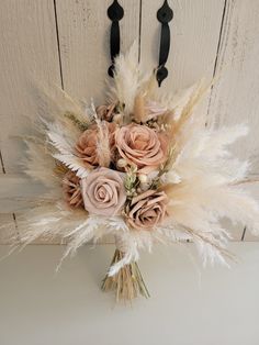 a bridal bouquet with feathers and roses