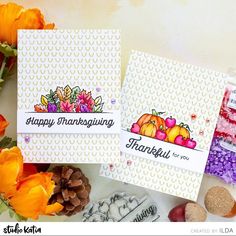 two cards with thanksgiving images on them and some flowers in the foreground, along with other card making supplies