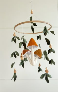 a mobile with mushrooms and leaves hanging from it