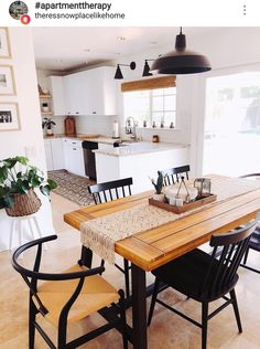 a dining room table and chairs in front of an open kitchen