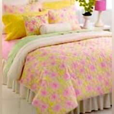 a bed with pink, yellow and green comforters