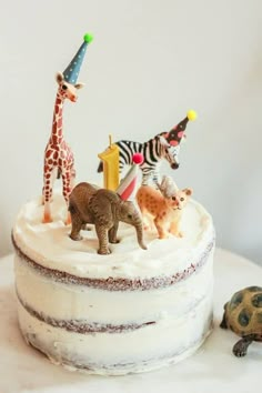 a cake decorated with toy animals and giraffes