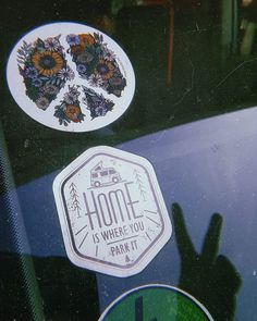 some stickers on the side of a car window that says home is where you park it