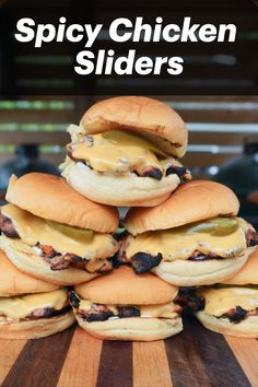 a pile of chicken sliders sitting on top of a wooden cutting board with the words spicy chicken sliders