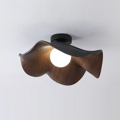 a modern wooden ceiling light with an unusual shape on the top and bottom, which is shaped like a flower