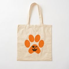 a tote bag with an orange paw print and a black cat's face