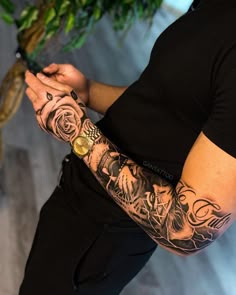 a man with tattoos on his arm holding a cell phone