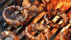 sausages and hot dogs are cooking on the grill