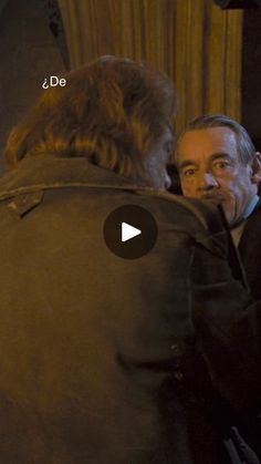 a man in a black jacket is talking to another man