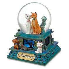 a snow globe with three cats and a dog in it on top of a building