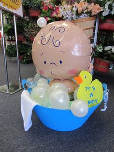 an inflatable balloon sitting on top of a blue tub filled with balloons