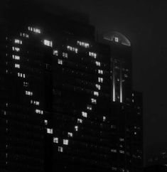 the building is lit up at night with lights on it's sides and windows