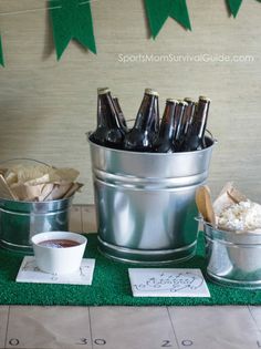 there are several buckets with drinks in them on the green carpeted tablecloth