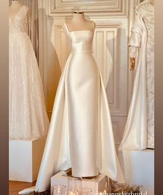 wedding gowns are displayed on display in front of white walls and floor - length windows