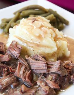 a white plate topped with meat and mashed potatoes