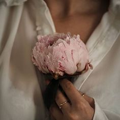 a close up of a person holding a flower