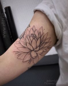 a woman's arm with a flower tattoo on it