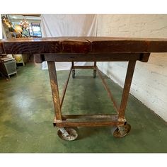 an old wooden table on wheels in a room