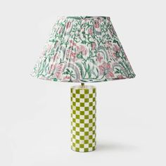 a green and white checkered lamp with a pink flowered shade on the base