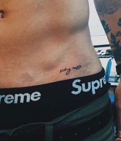 a man's stomach with the word supreme tattooed on his side and an inscription underneath it