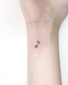 a small music note tattoo on the wrist