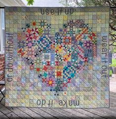 a quilt hanging on the side of a building