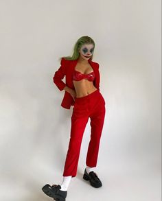 a woman in a red suit and clown makeup